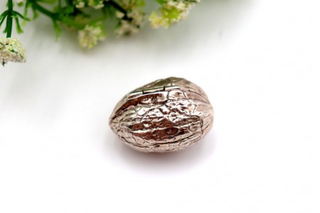 Caixa de comprimidos em prata em forma de noz em vulto perfeito